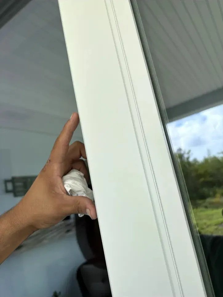 Joel wiping down a white sliding door frame after a repair